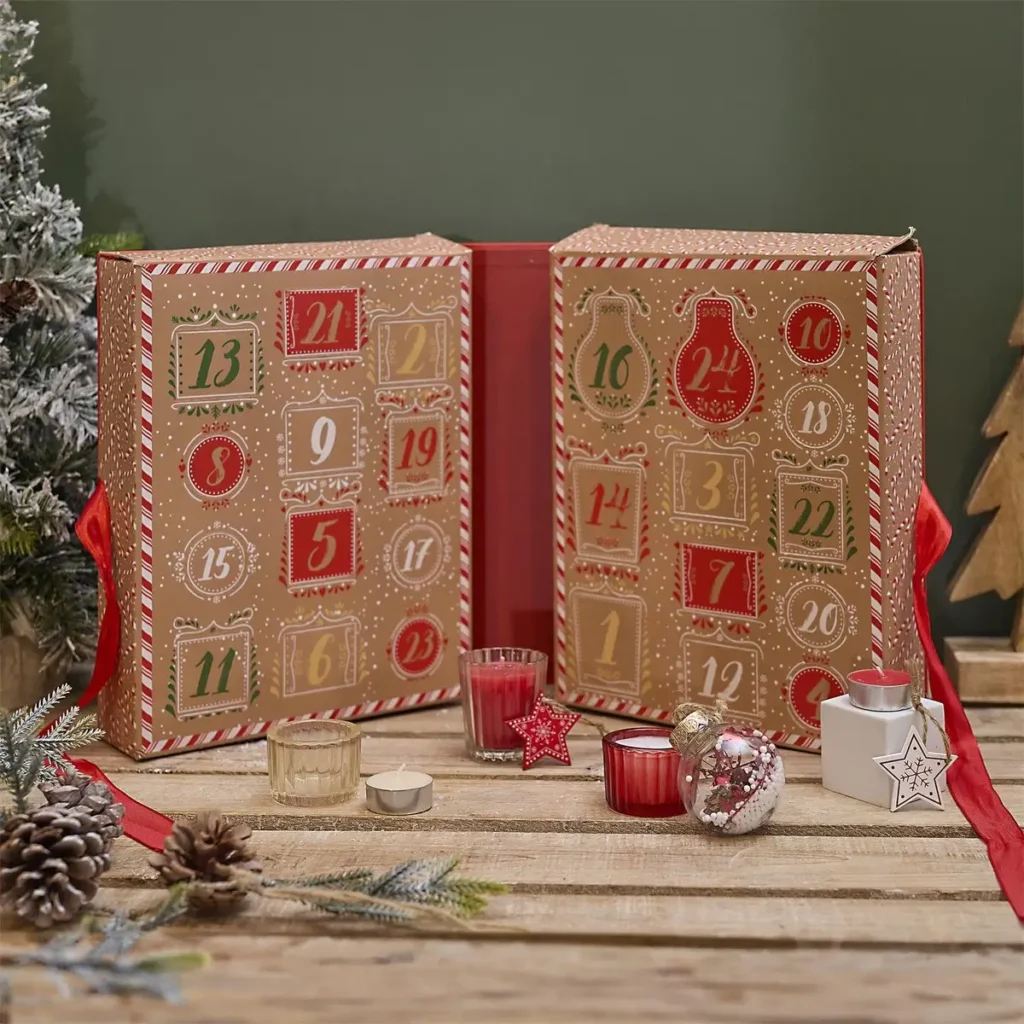 Geopende adventskalender met kerstkaarsen in rode cadeauverpakking